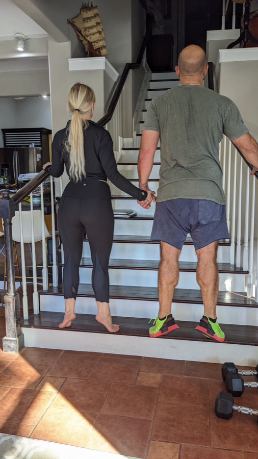 Couple doing calf raises together on their staircase at home